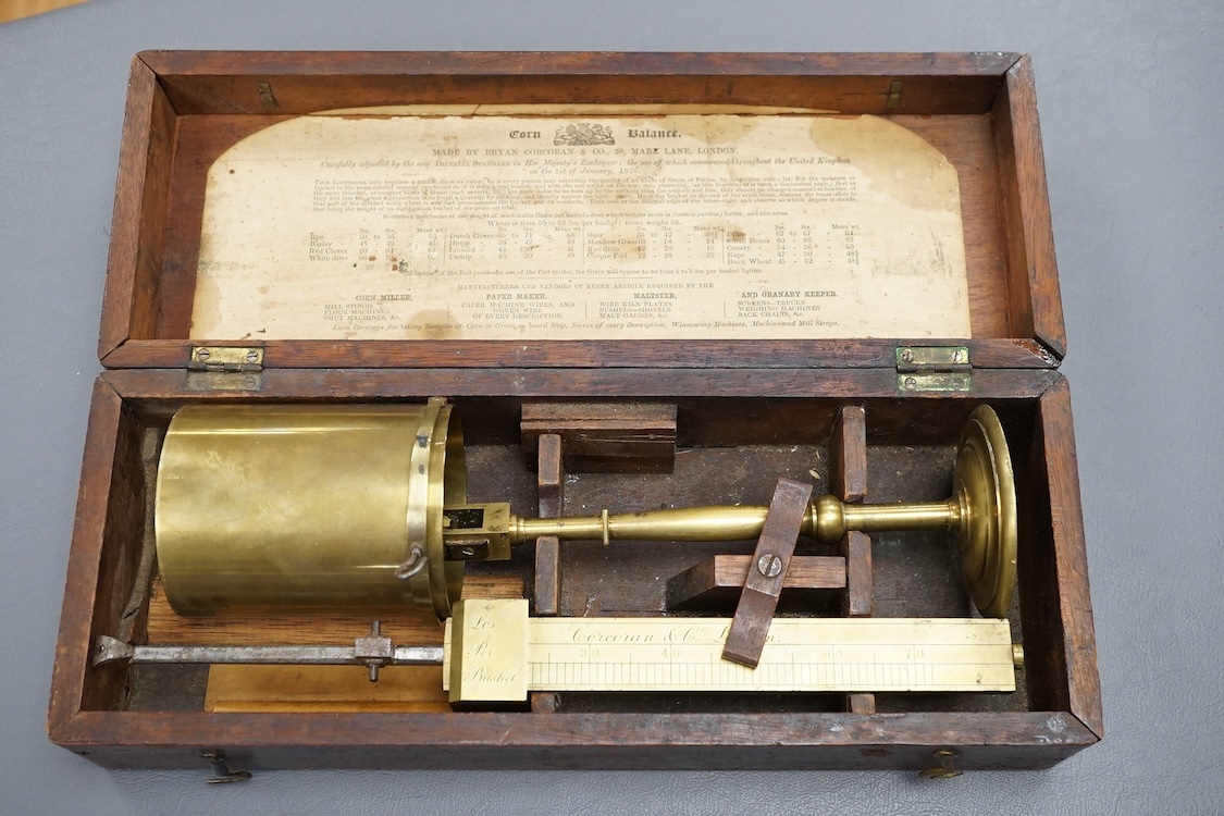 A 19th century mahogany cased brass Corn Balance, made by Bryan Corcoran & Co., 36, Mark Lane, London, with engraved scale and sliding balance marked with; ‘Lbs Per Bushel’, in its original fitted case with paper label t